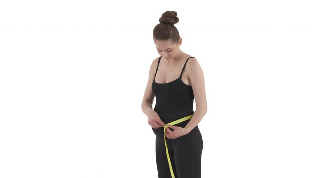 Pregnant Caucasian woman measuring her belly size with tape measure. Health maternity concept. Isolated on white background.