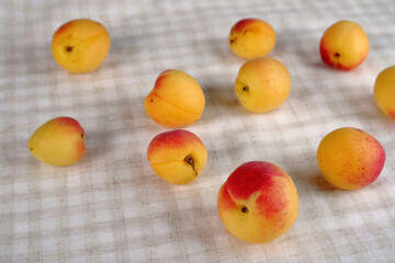 Juicy apricots on a checkered cotton background.