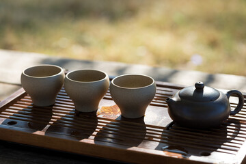 Chinese tea ceremony. Ceramic teapot made of clay and bowls on a wooden background.