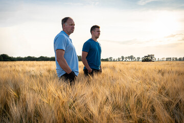 Ackerbau - Düngeverordnung, zwei Landwirte stehen am Abend in einem Getreidefeld