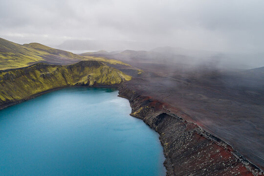 Aerial view of crater lake Blahylur, also known as Hnausapollur, with rainshowers, Fjallabak, highlands of Iceland