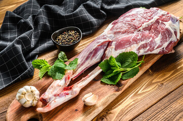 Sheep, lamb leg with herbs. Raw organic meat. Wooden background. Top view