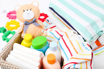 Clothes with stoys and baby supplies on white background - obrazy, fototapety, plakaty