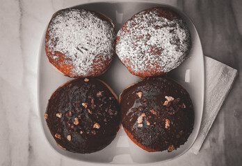 top view of chocolate and caramel doughnuts on a white plate.