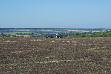 the tractor plows the mown wheat field