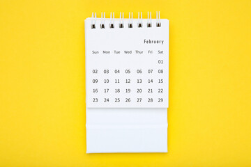 Paper calendar page on yellow background