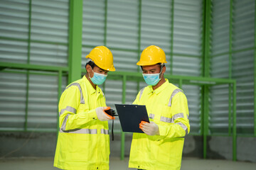 Warehouse worker with safety equipment working check stock chart for logistic import export in a large warehouse.