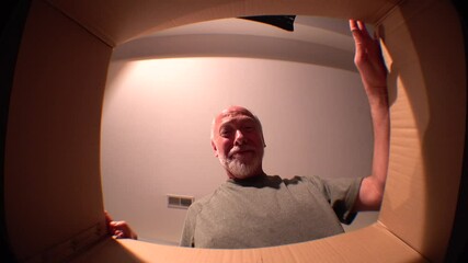 POV opening carton box delivery on quarantine gift purchase. Male looking in box and happy to receiving products. Home isolation happy smiling after courier e-commerce delivery