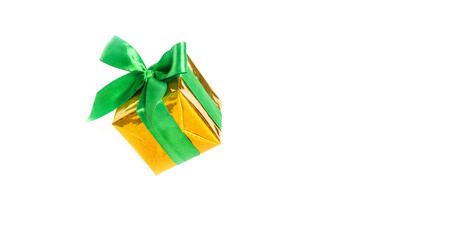 Shiny yellow gift box with green ribbon isolated on white background.