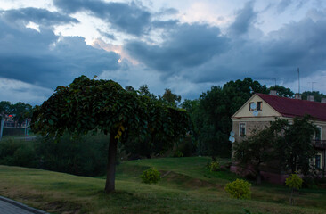 Grodno, Belarus. Old house in a ravine, green tree against the background of the evening sky.