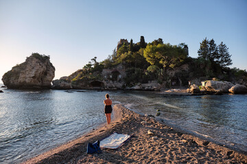 Fototapeta na wymiar Young woman photographing the beautiful island Isola Bella