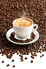Cup with coffee on the background of coffee beans