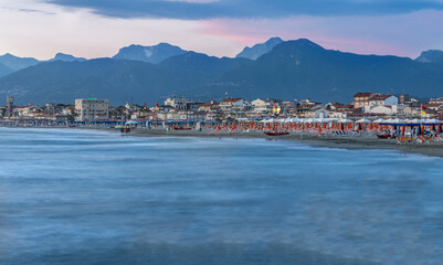 Fototapeta premium The view from the Viareggio pier at sunset is spectacular, the Apuan Alps appear in the background.