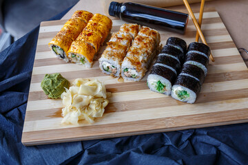 Set of traditional Japanese dishes. Sushi rolls, nigiri, raw salmon, rice, cream cheese, avocado, pickled ginger.