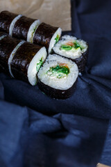 Set of traditional Japanese dishes. Sushi rolls, nigiri, raw salmon, rice, cream cheese, avocado, pickled ginger.