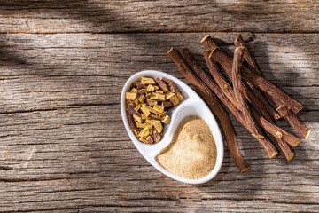 licorice root and powder, on the wooden table