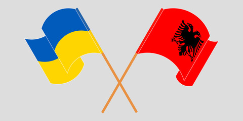 Crossed and waving flags of Albania and the Ukraine