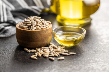 Peeled sunflower seeds in wooden bowl and oil.