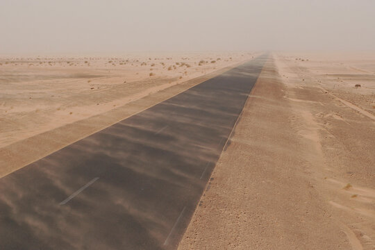 Dust plumes across the road in sandstorm at Sahara