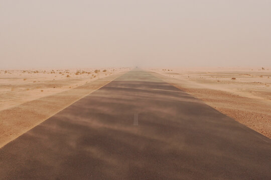 Dust plumes across the road in sandstorm at Sahara
