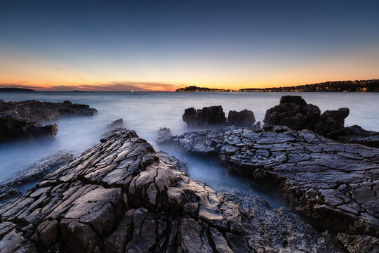Sea shore with rocks at sunset. Seascape in summer time. Rocks and water. Long exposure. Mediterranean sea. Travel - image.