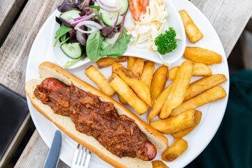 Food on the English Pub such as hot dog with beefy sauce, chips and salad