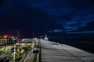 pier with church on the background of the night cloudy sky
