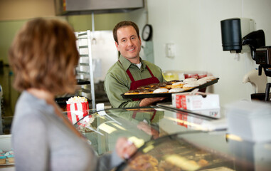 Bakery: Baker Brings Out New Tray of Donuts