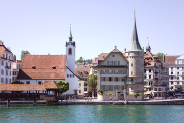 Fototapeta na wymiar Cityscape of Lucerne, riverbank with old architecture, unrecognisable people. Switzerland.