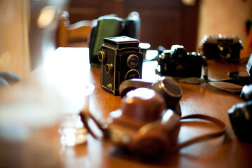 Vintage cameras collection on wooden table in sunny kitchen