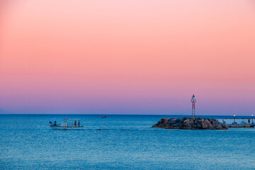 Obraz premium Sunset on Chios Island in Greece while a boat leaving the port