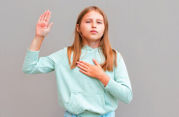Optimistic, honest and cute girl give oath, swear tell truth, put hand on heart and raise one arm...
