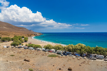 The amazing tropical beach of Panagia Tripiti, in Crete, with sandy beach, turquoise water and some lucky campers, Greece.