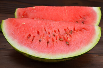 two slices of watermelon with appetizer red pulp with seeds close-up
