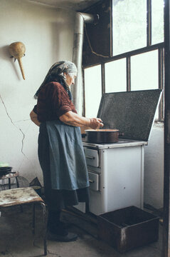 Senior woman standing next to a stove