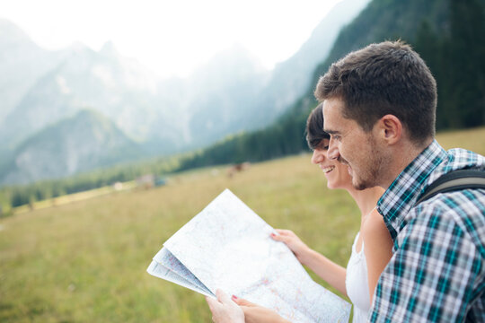 Hiking couple check map for direction