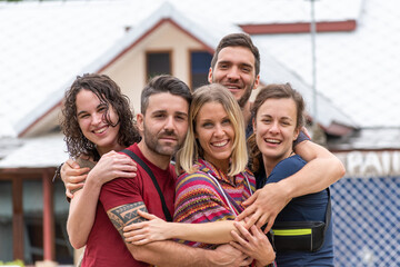 5 friends hug each other for a souvenir photo during their vacation.