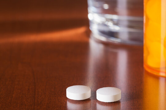 Medicine on bedside table with glass of water