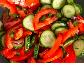 Vitamin salad from fresh vegetables close-up. Contains tomatoes, cucumbers, peppers. Seasoned with vegetable oil