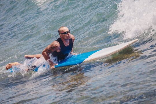 Surfer Paddling Out Over a Wave on his Board