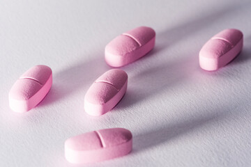 Pink pills on a white background. vitamins.