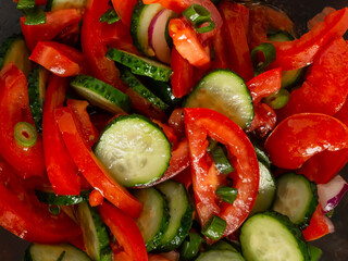 Vitamin salad from fresh vegetables close-up. Contains tomatoes, cucumbers, peppers. Seasoned with vegetable oil