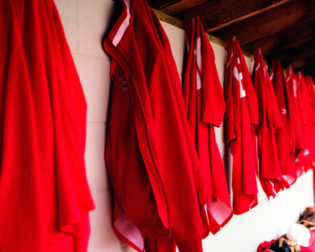 Baseball jerseys hanging on pegs in a dugout shot on medium format film.