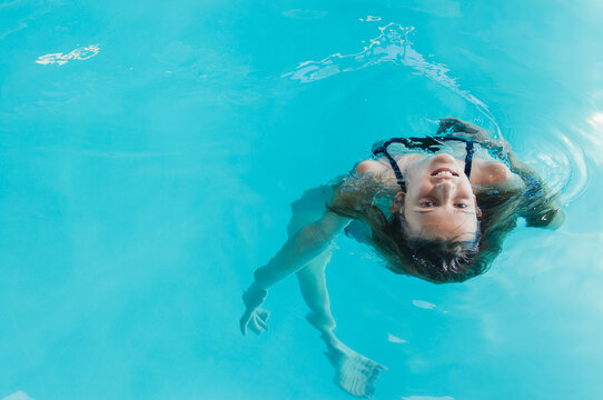girl playing in water in swimming pool