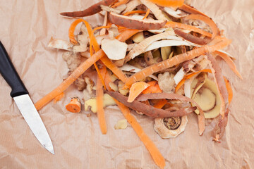 Peelings of root vegetables on parchment paper with a knife