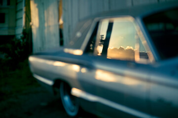 Sunset clouds reflected in the window of a vintage car