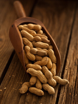 Scoop of peanuts on wooden texture