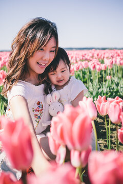Happy Asian mother and daughter spending time together in a tulip field