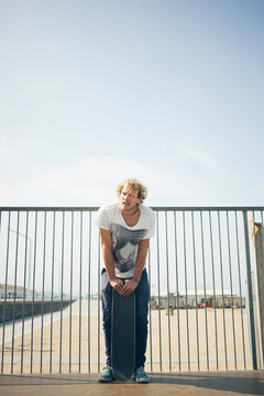 Skater standing on a half-pipe with his skateboard