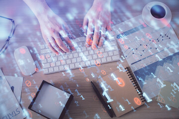 Double exposure of man's hands typing over computer keyboard and data theme hologram drawing. Top view. Technology concept.